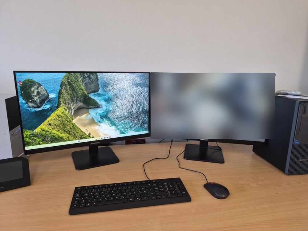 Radno mjesto s dva monitora, na desnom je zamućena slika kamera